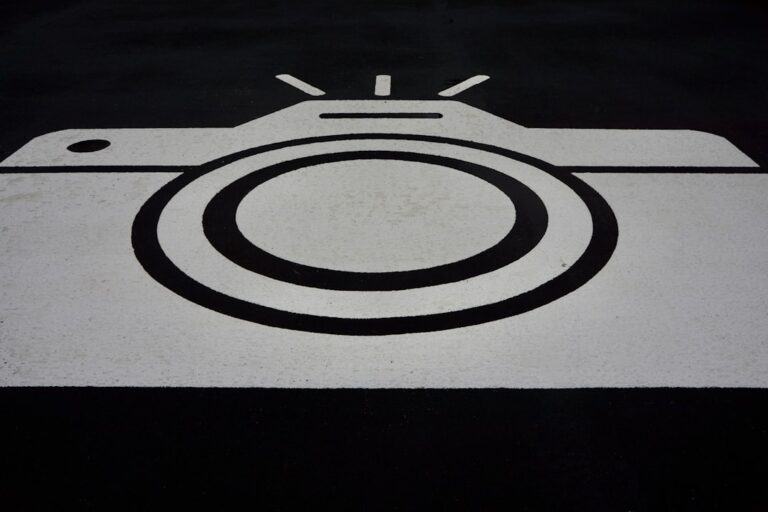 A black and white graphic of a camera painted on asphalt.